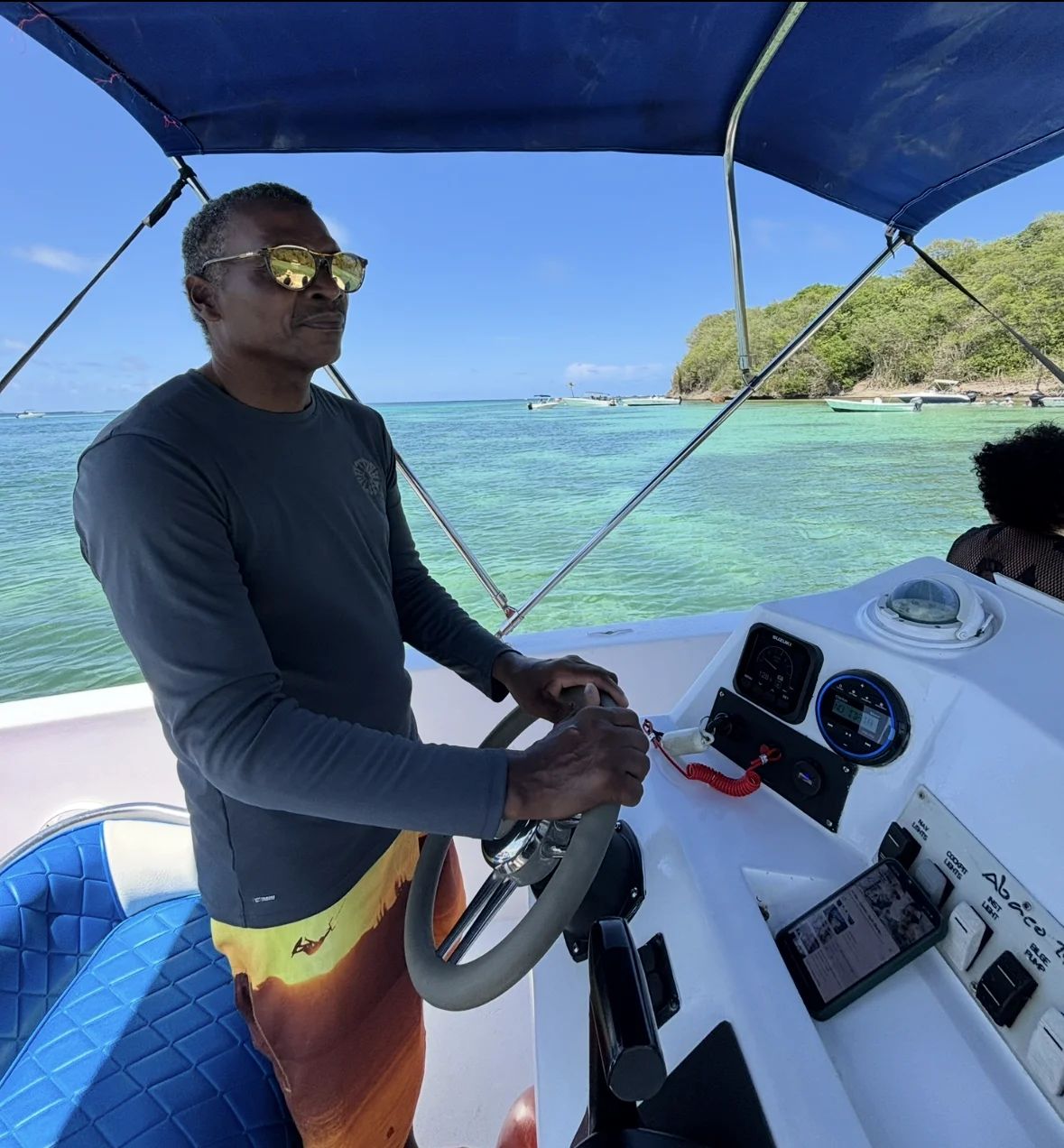 Le capitaine MOWATA à la barre du bateau dans la baie du François