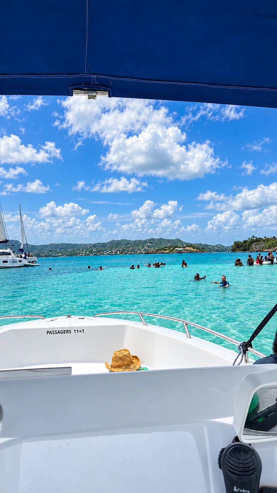 Baigneurs debout dans l'eau turquoise de la Baignoire de Joséphine, vus depuis le bateau